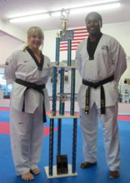 Taekwondo Duo: Amy Maillet and Master Fredson Gomes with the huge trophy won by MTC students in a recent tournament.